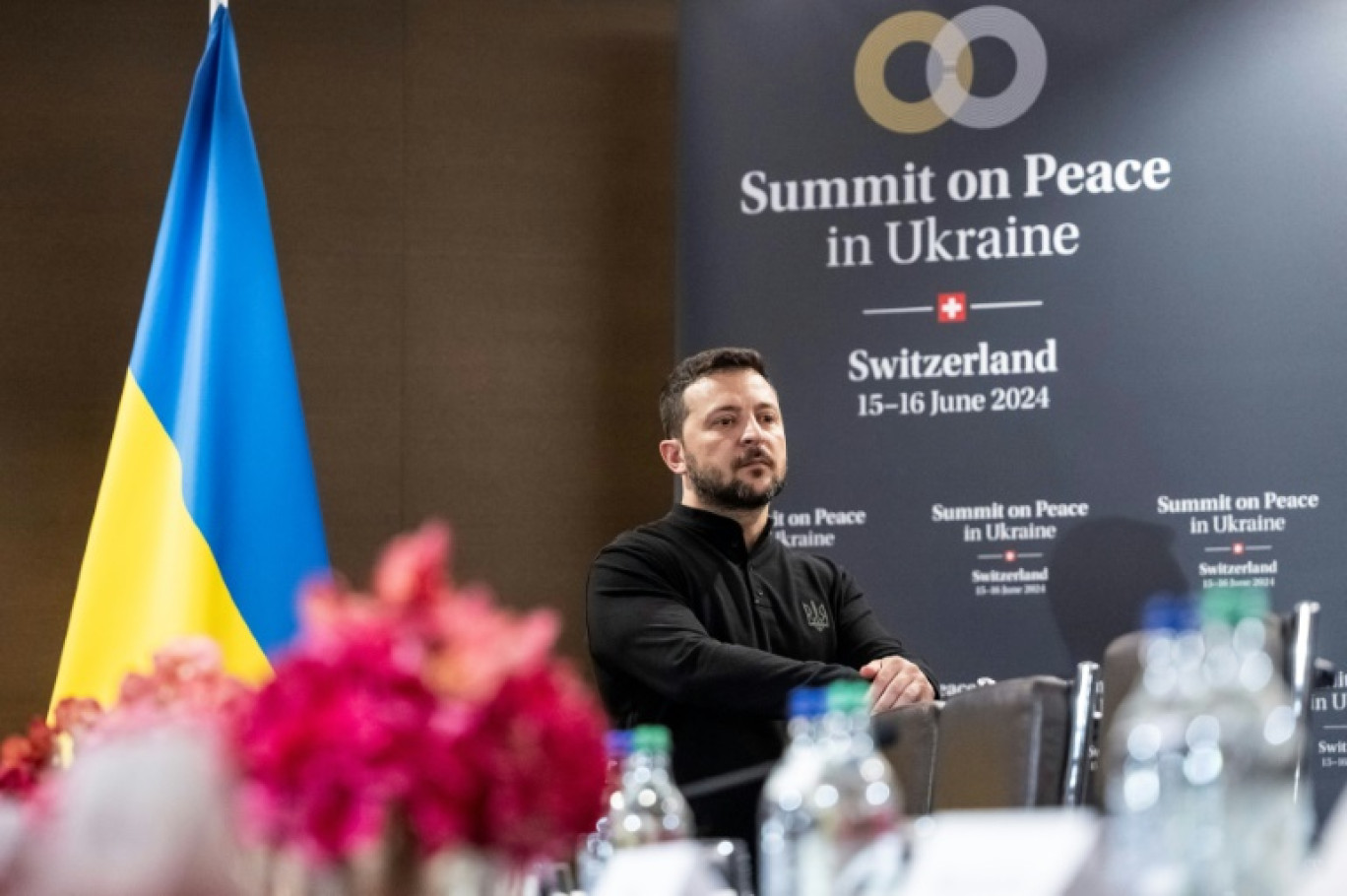 Le président ukrainien Volodymyr Zelensky lors d'un discours retransmis sur écrans au Sommet pour la paix en Ukraine, le 15 juin 2024 à Burgenstock, près de Lucerne, en Suisse © URS FLUEELER