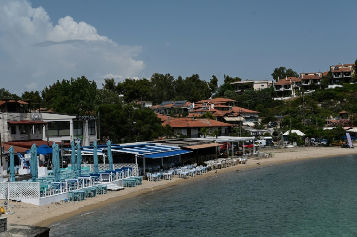 Des bars et restaurants les pieds dans le sable, sur une plage de la péninsule de Chalcidique, en Grèce, le 7 juin 2024 © Sakis MITROLIDIS