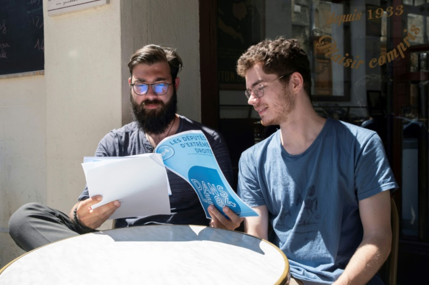 Antonin Dacos (d) et Alexandre Lorello, membres de l'Observatoire de l'extrême droite dans le Vaucluse, regardent un rapport qu'ils ont rédigé sur l'extrême droite à Avignon, le 17 juin 2024 © Jérémy PAOLONI