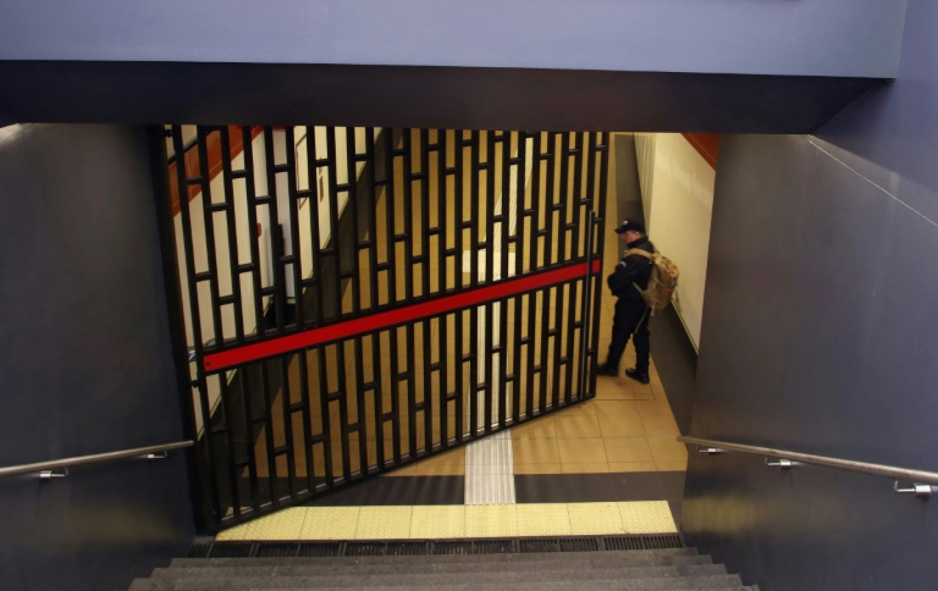 Un agent de sécurité ferme la porte de la station de métro Recreo à Quito après une panne d'électricité le 19 juin 2024 © Galo Paguay