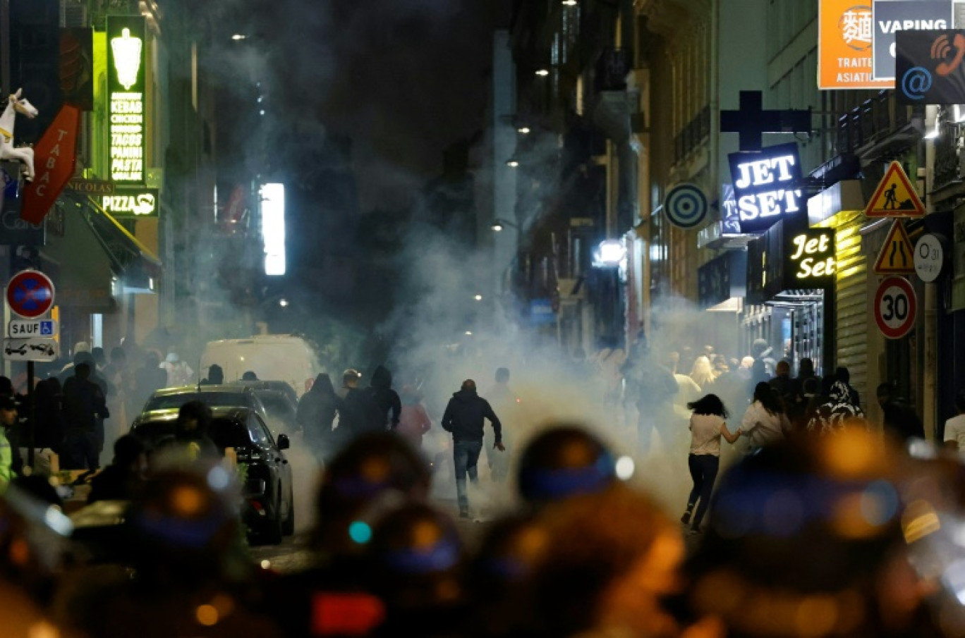 Des manifestants détalent alors que des policiers utilisent des gaz lacrymogènes à Paris le 2 juillet 2023, cinq jours après la mort de Nahel à Nanterre (Hauts-de-Seine) © Ludovic MARIN