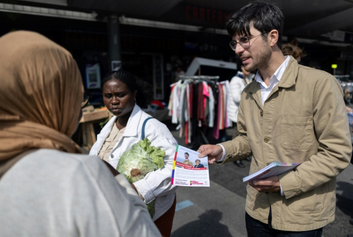 Pierre-Yves Cadalen, candidat LFI investi par le Nouveau Front populaire, distribue aux habitants sa profession de foi sur le marché de Brest, le 20 juin 2024 dans le Finistère © Fred TANNEAU