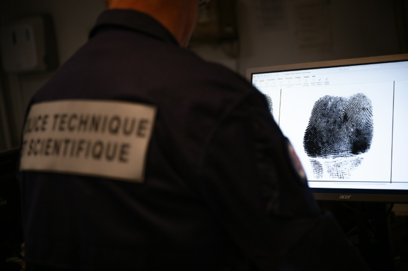 Un policier examine une empreinte digitale au Service Interdépartemental de la Police Judiciaire (SIPJ) à Rouen, le 13 juin 2024 © LOU BENOIST