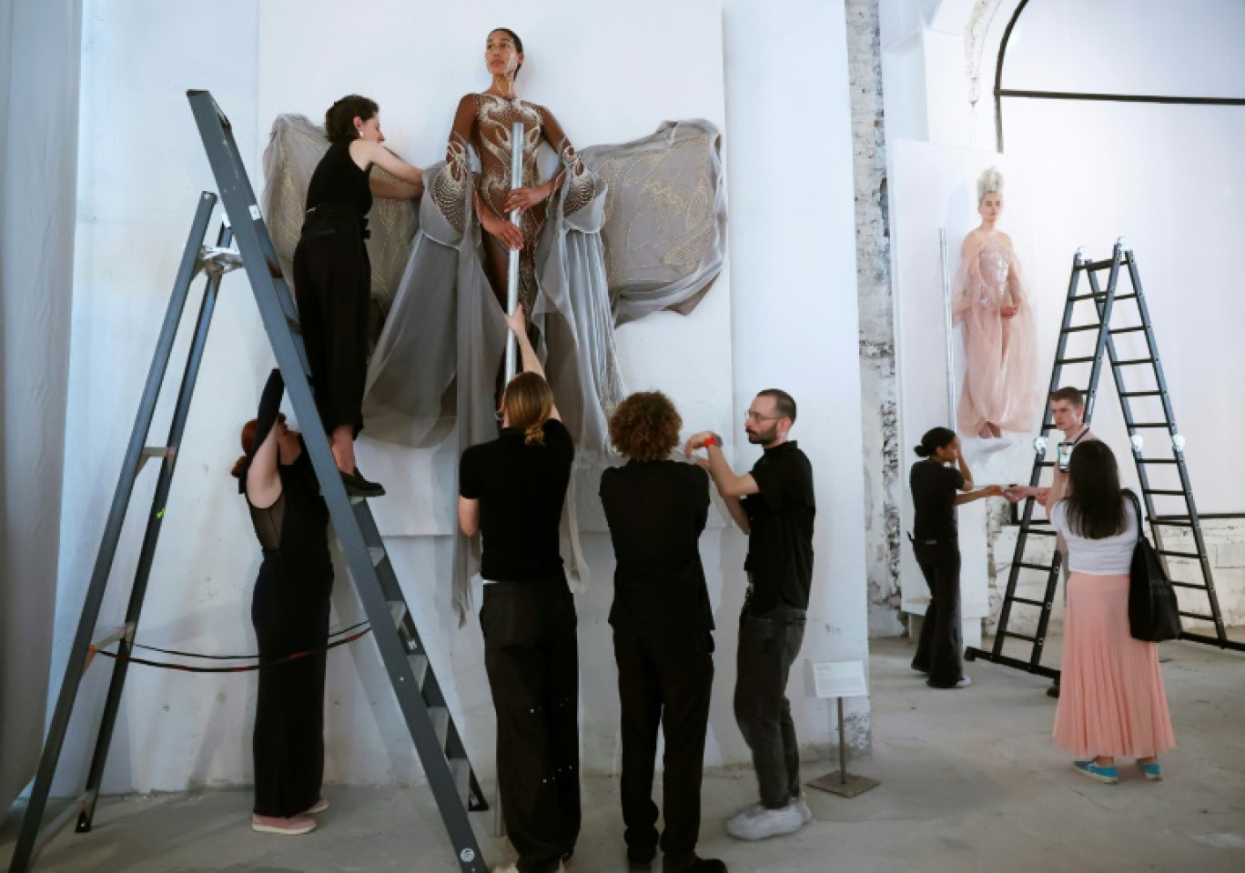 Un mannequin, création artistique de la Néerlandaise Iris Van Herpen, est décroché de sa structure lors de la semaine de la Haute couture à Paris, le 24 juin 2024 © Emmanuel Dunand