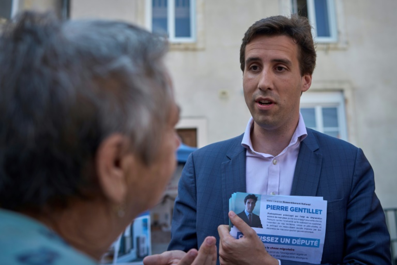 Pierre Gentillet, ex-chroniqueur sur CNews et candidat RN aux législatives dans le Cher, parle avec une habitante sur le marché de Sancoins, le 26 juin 2024 © Guillaume SOUVANT