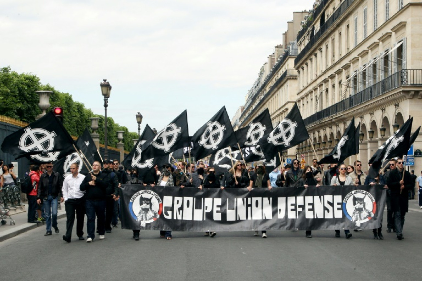 Des membres du syndicat étudiant d'ultradroite GUD (Groupe Union Défense) tiennent une banderole et des drapeaux avec le symbole nationaliste de la croix celtique à Paris, le 8 mai 2011 © Thomas SAMSON