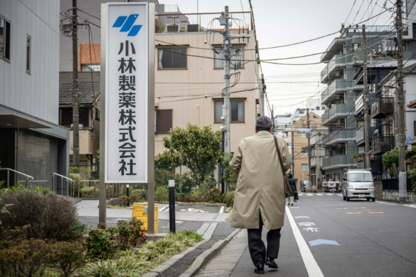 Un homme passe devant un panneau de Kobayashi Pharmaceutical face au bureau de la compagnie à Tokyo, au Japon le 28 mars 2024 © Yuichi YAMAZAKI