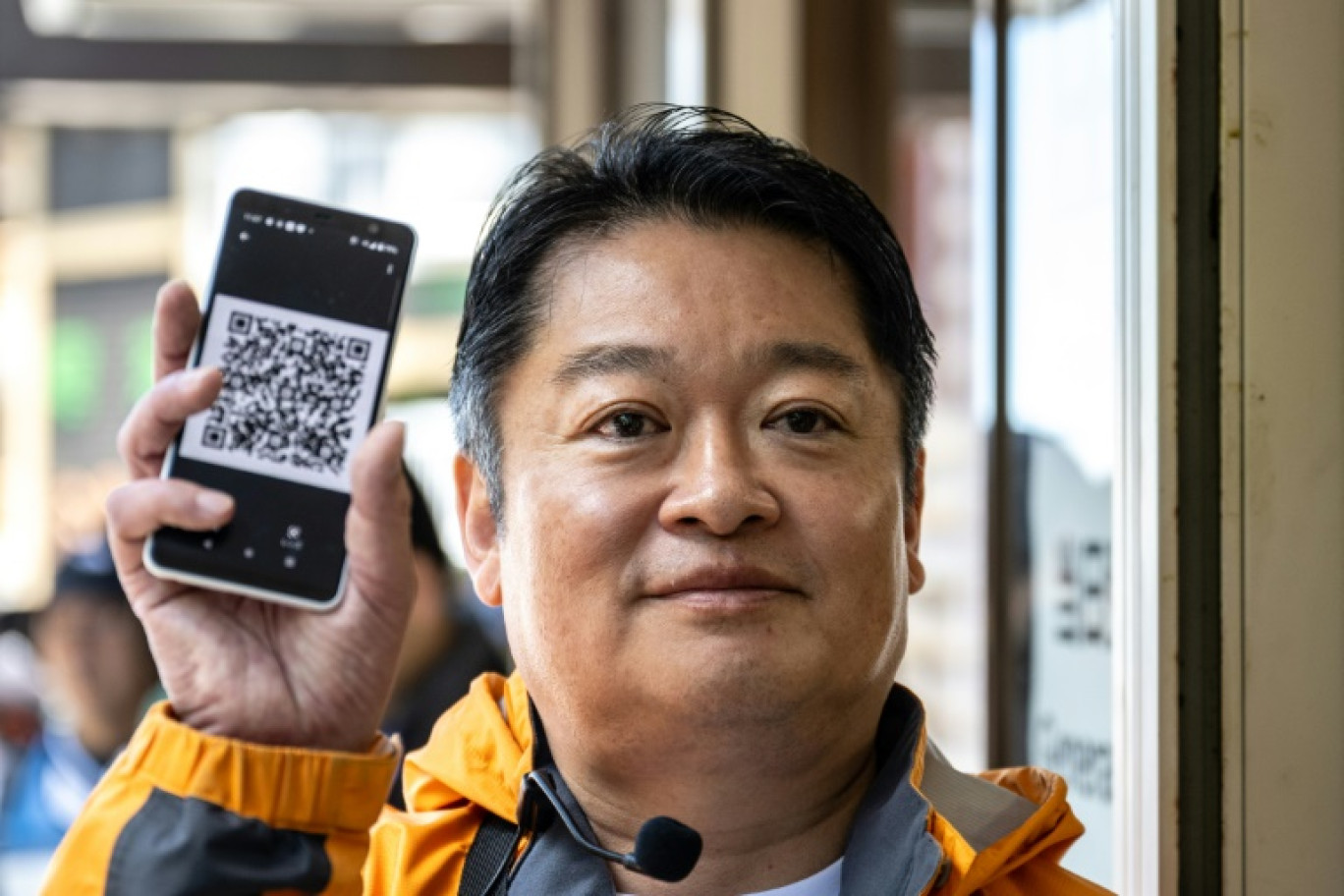 Le gouverneur de la préfecture de Yamanashi, Kotaro Nagasaki, présente un QR code et les nouvelles procédures de paiement d'entrée pour gravir le mont Fuji, le 19 juin 2024 © Philip FONG