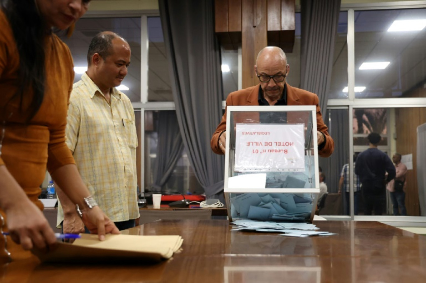 Un assesseur vide l'urne pour commencer le dépouillement du 1er tour des législatives dans un bureau de vote à La Possession, sur l'île de La Réunion, le 30 juin 2024 © Richard BOUHET
