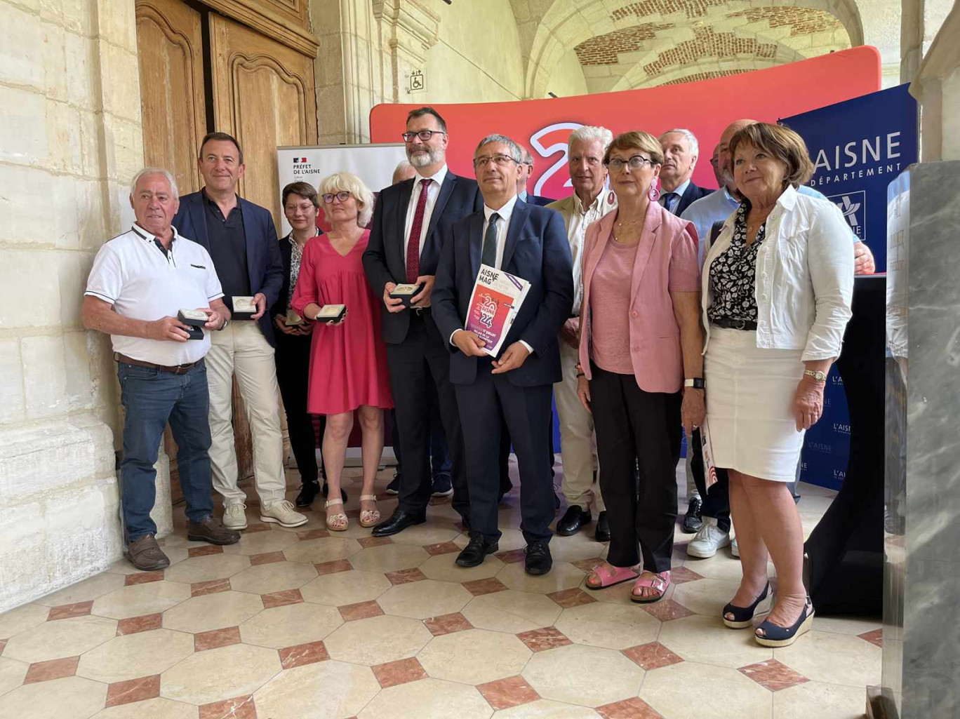 Thomas Campeaux, préfet de l'Aisne et Nicolas Fricoteaux, président de l'Aisne (au centre), avec les élus des villes traversées par le relais de la flamme olympique.