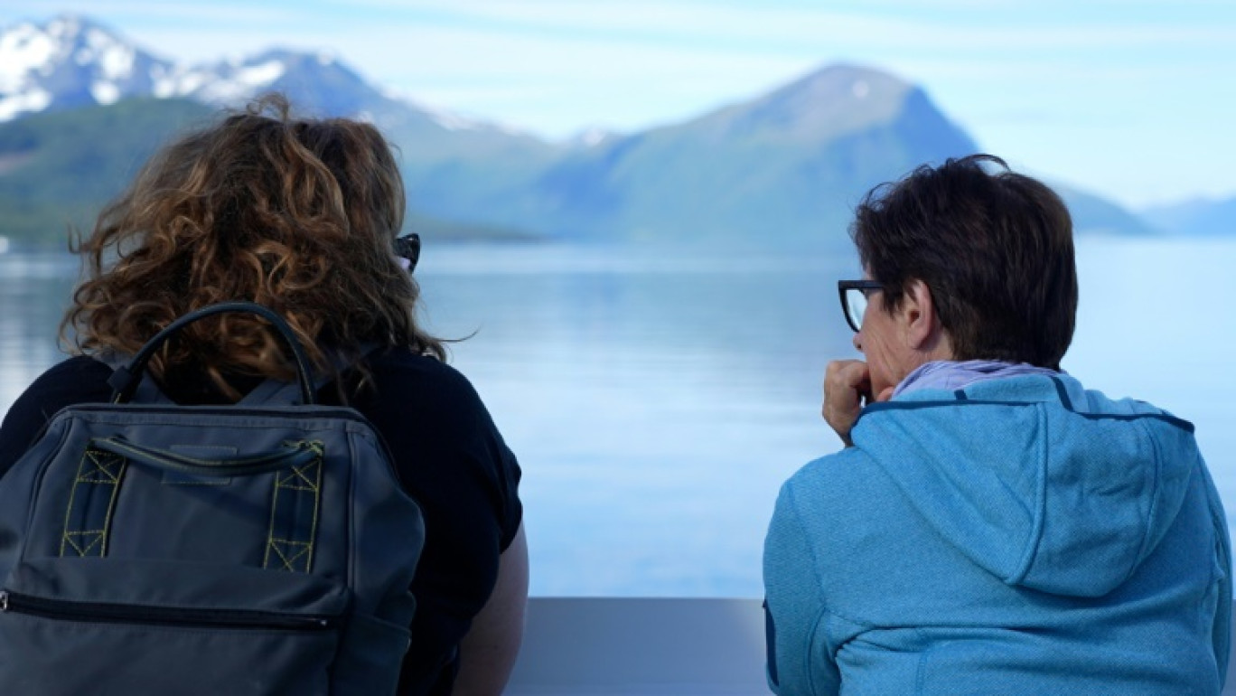 Des touristes admirent le paysage à bord d'u ferry à Margerholm, en Norvège, le 27 juin 2024 © Olivier FENIET