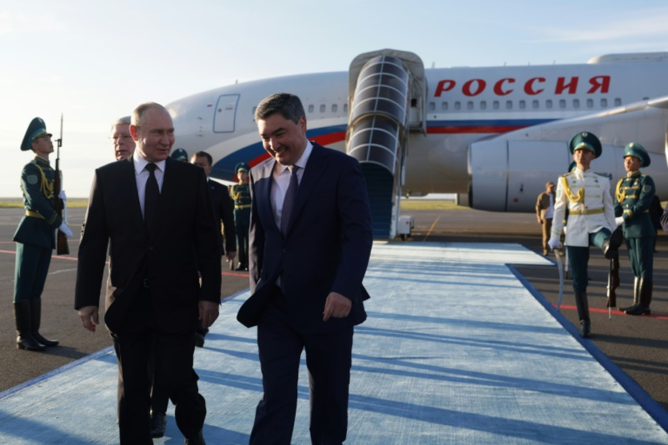 Le président russe Vladimir Poutine (g) accueilli par le Premier ministre kazakh Olzhas Bektenov à son arrivée à l'aéroport d'Astana, le 3 juillet 2024 © Gavriil GRIGOROV