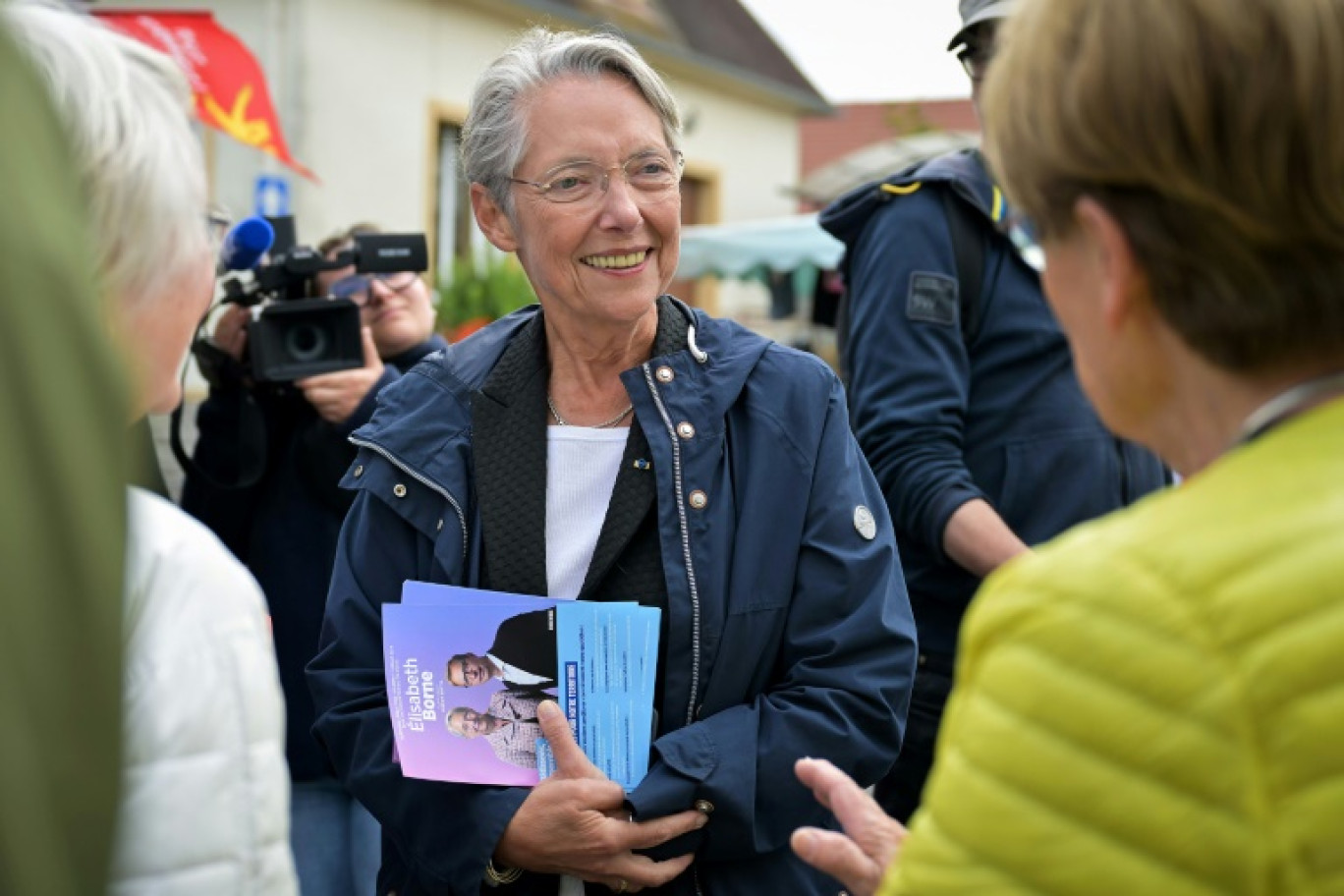 L'ancienne Première ministre Elisabeth Borne (c), candidate de la coalition de droite Ensemble aux législatives, distribue des tracts sur un marché à Villers-Bocage, le 3 juillet 2024 dans le Calvados © Lou Benoist