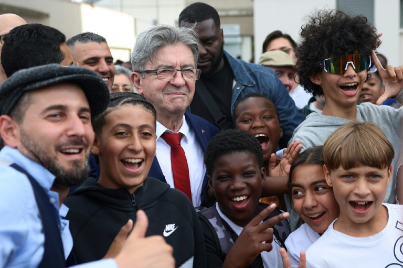 Le leader LFI Jean-Luc Mélenchon (c) rencontre des habitants lors d'une visite de soutien au candidat du Nouveau Front Populaire (NFP) aux législatives, Adel Amara (g), le 5 juillet 2024 à Villiers-sur-Marne, dans le Val-de-Marne © EMMANUEL DUNAND