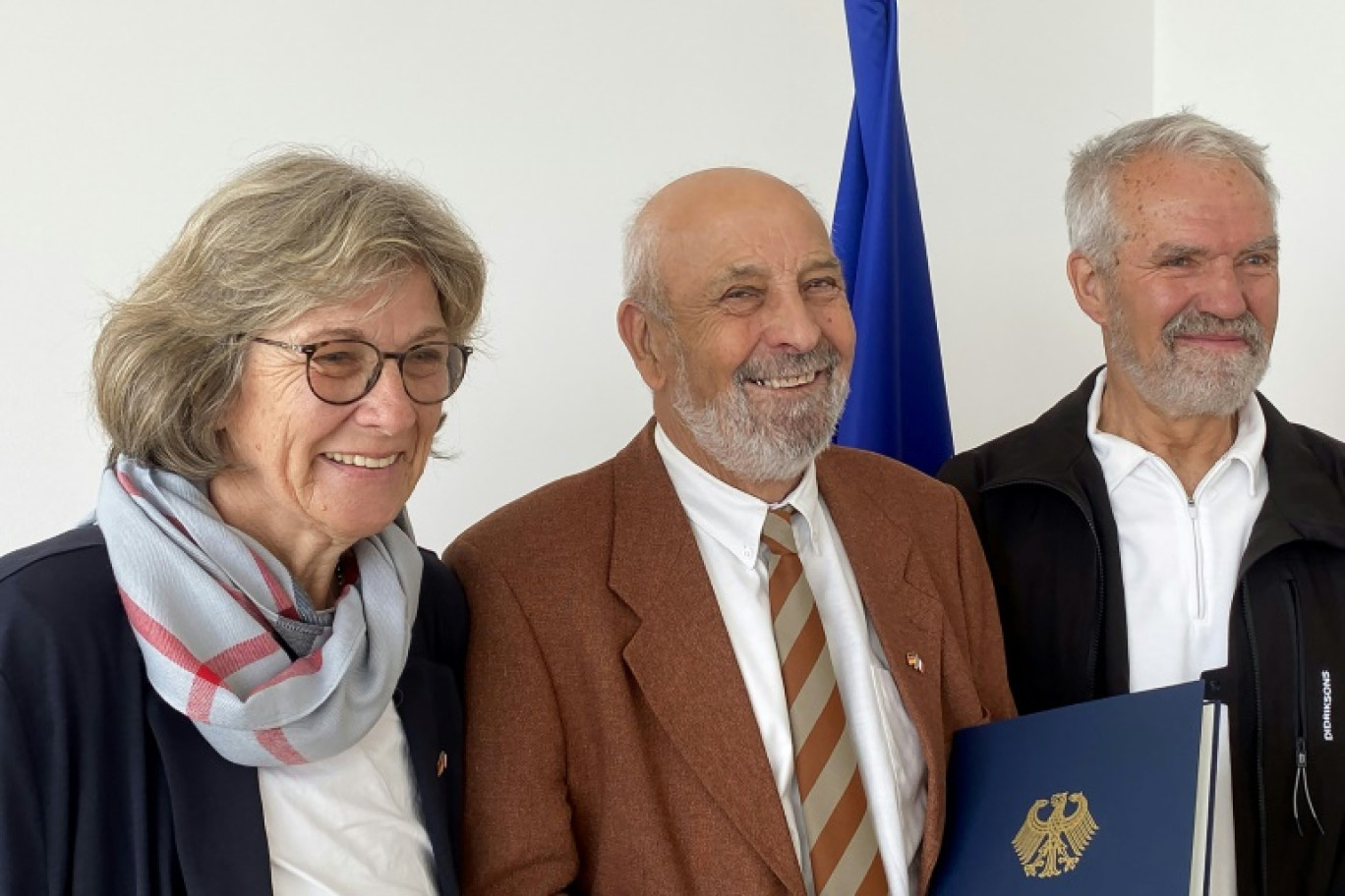 Thierry Soudan (c), fils d'un soldat allemand, entouré de sa demi-sœur allemande Waltraut Maurer (g) et de son demi-frère Manfred Christ (d), après avoir été naturalisé citoyen allemand à l'ambassade d'Allemagne à Paris, le 3 juillet 2024 © Ulrike KOLTERMANN