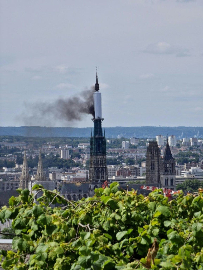 De la fumée s'échappe de la flèche de la cathédrale de Rouen le 11 juillet 2014 après un début d'incendie "rapidement maîtrisé mais pas éteint" en début d'après-midi par les pompiers. © Patrick STREIFF