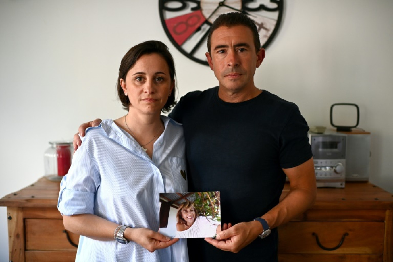 Marjorie et Guillaume Bonvoisin, les enfants de Florence Taillade, tiennent une photo de leur mère, le 10 juillet 2024 à Andernos-les-Bains, en Gironde © Christophe ARCHAMBAULT