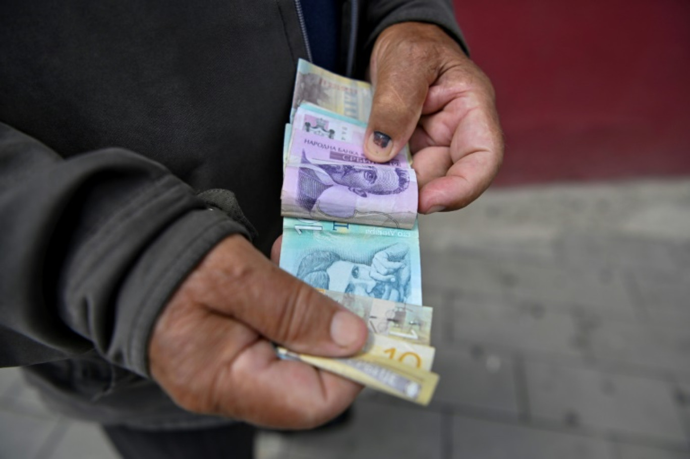 Un homme montre des billets de dinars serbes à Gracanica, le 3 juillet 2024 au Kosovo © Armend NIMANI