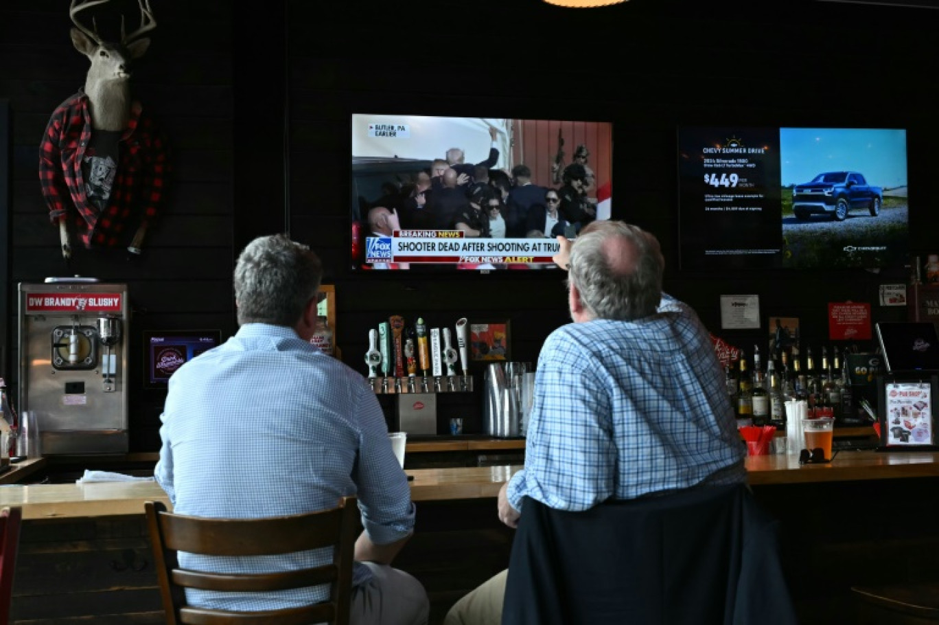 Des habitants suivent dans un bar les nouvelles télévisées après la tentative d'assassinat contre l'ancien président américain Donald Trump, le 13 juillet 2024 à Milwaukee, dans le Wisconsin © ANGELA WEISS