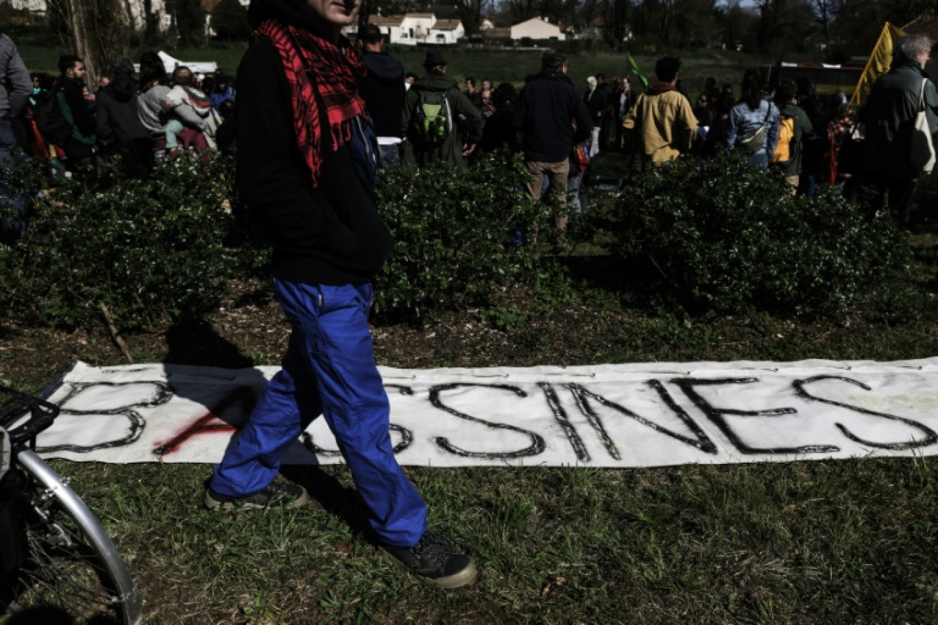 Un manifestant devant une banderole  "Bassines" à Melle le 23 mars 2024 © Thibaud MORITZ