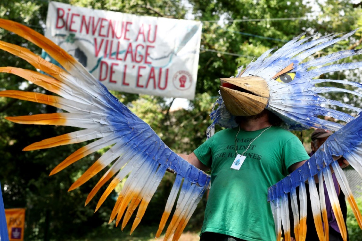 Un homme déguisé en oiseau accueille les participants au "Village de l'eau", près de Saint-Martin-lès-Melle, le 16 juillet 2024 © ROMAIN PERROCHEAU