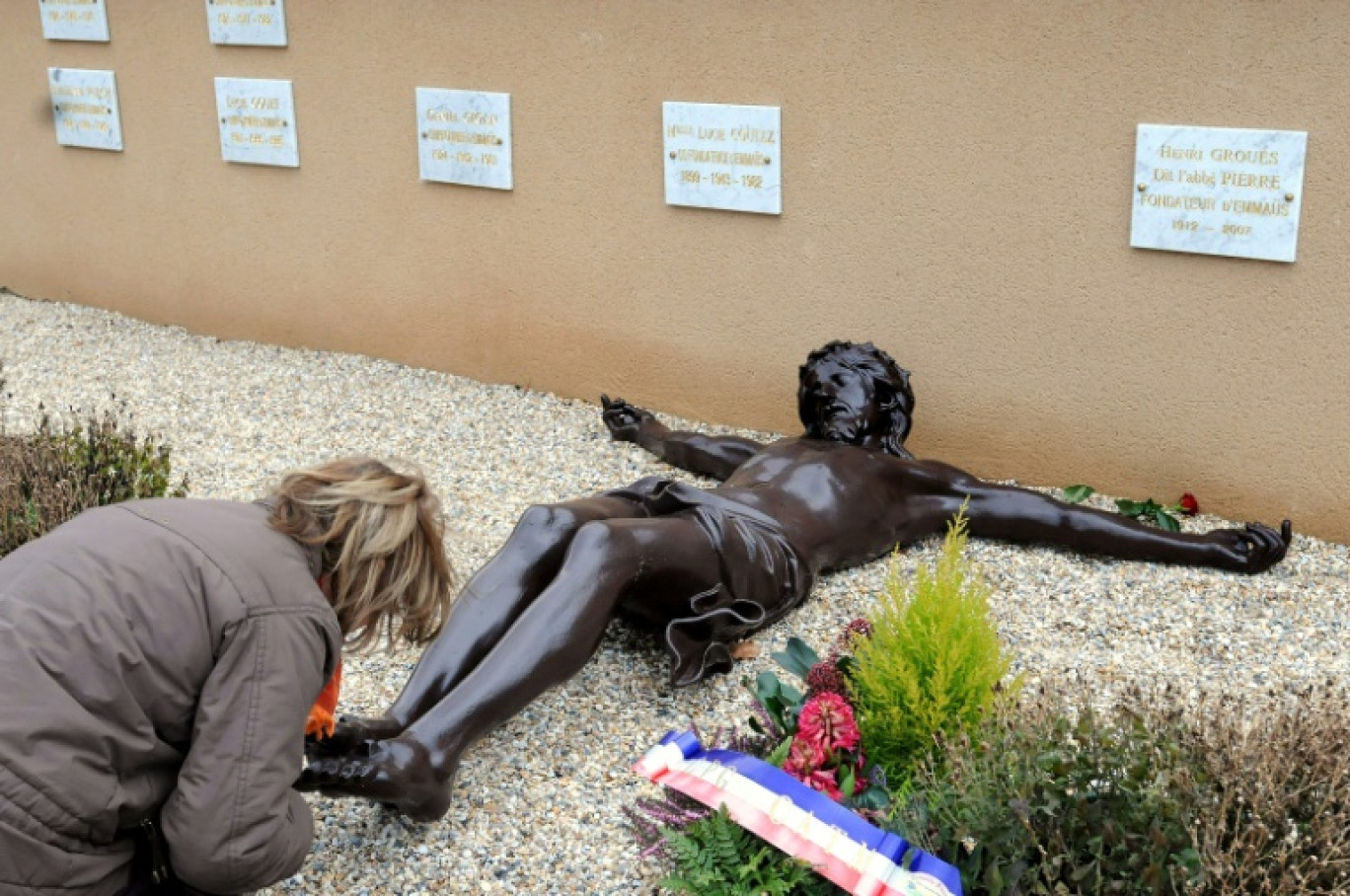 Une personne se recueille sur la tombe de l'abbé Pierre à Esteville en Seine-Maritime le 14 janvier 2008 © ROBERT FRANCOIS