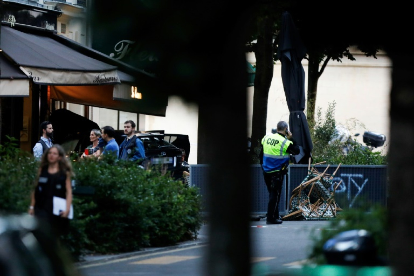 Des policiers près du lieu où un automobiliste a foncé sur la terrasse d'un café, le 17 juillet 2024 à Paris © Ian LANGSDON