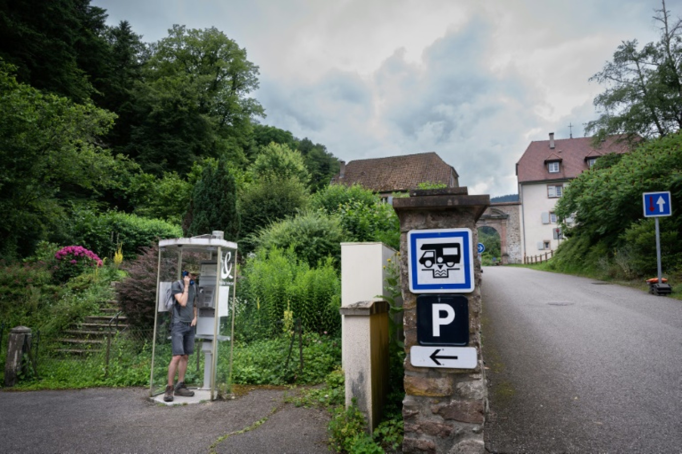 Un homme parle au téléphone dans la dernière cabine téléphonique publique française, à Murbach (Haut-Rhin), le 12 juillet 2024 © SEBASTIEN BOZON