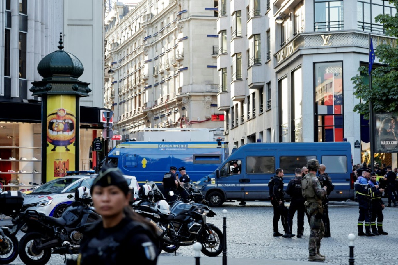 Des policiers, des gendarmes et un soldat sécurisent la zone devant une boutique Louis Vuitton après qu'un homme ait attaqué un policier avec un couteau, sur les Champs-Elysées, à Paris, le 18 juillet 2024. © STEPHANE DE SAKUTIN