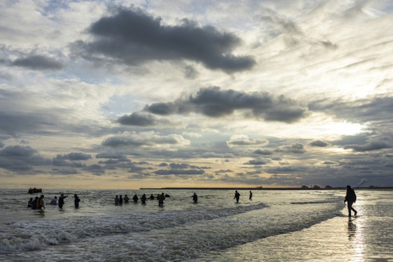 Des migrants tentent de monter à bord d'un bateau de passeurs pour  traverser la Manche, sur la plage de Gravelines, près de Dunkerque, le 26 avril 2024 dans le Nord © Sameer Al-DOUMY