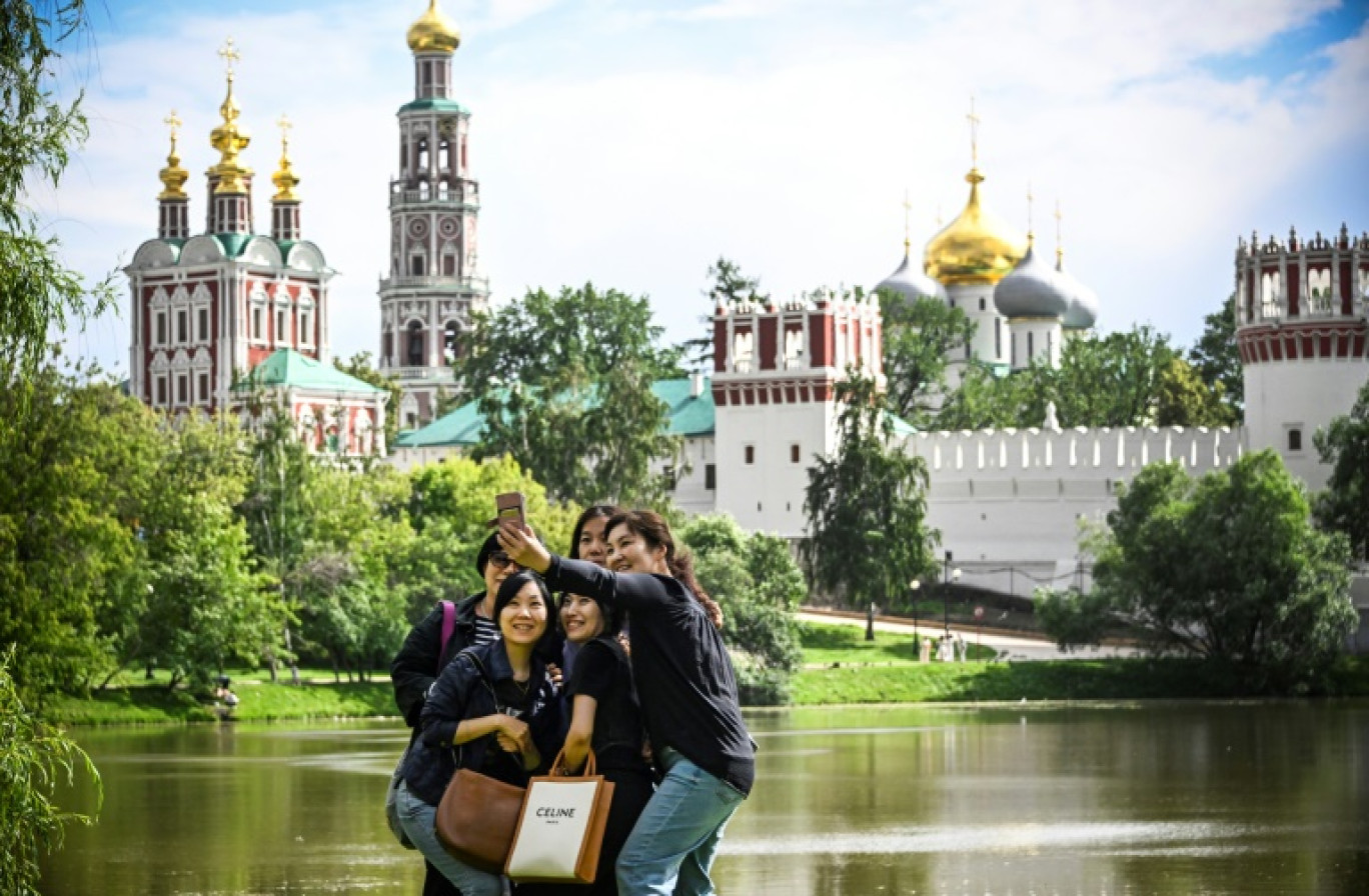 Des touristes asiatiques se prennent en photo devant le couvent de Novodevichy, le 25 juin 2024 à Moscou © Alexander NEMENOV