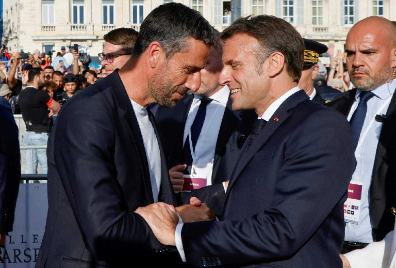 Le patron du comité d'organisation de Paris 2024 Tony Estanguet (G) serre la main du président  Emmanuel Macron à l'arrivée de la flamme olympique à Marseille le 8 mai 2024 © Ludovic MARIN