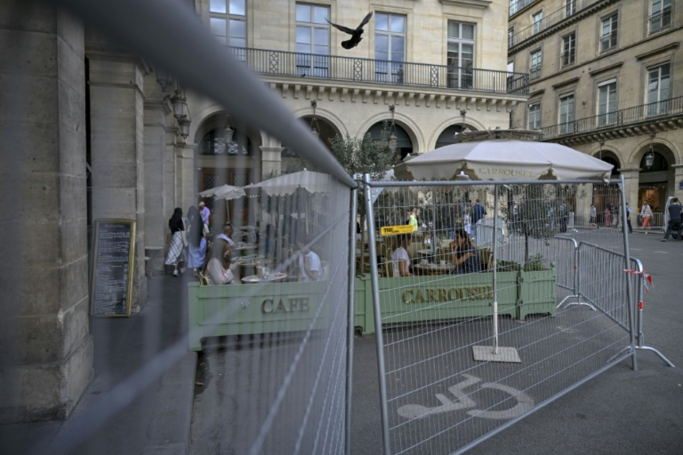 Un café à côté d'une clôture de zone de sécurité à Paris, le 22 juillet 2024 © MAURO PIMENTEL