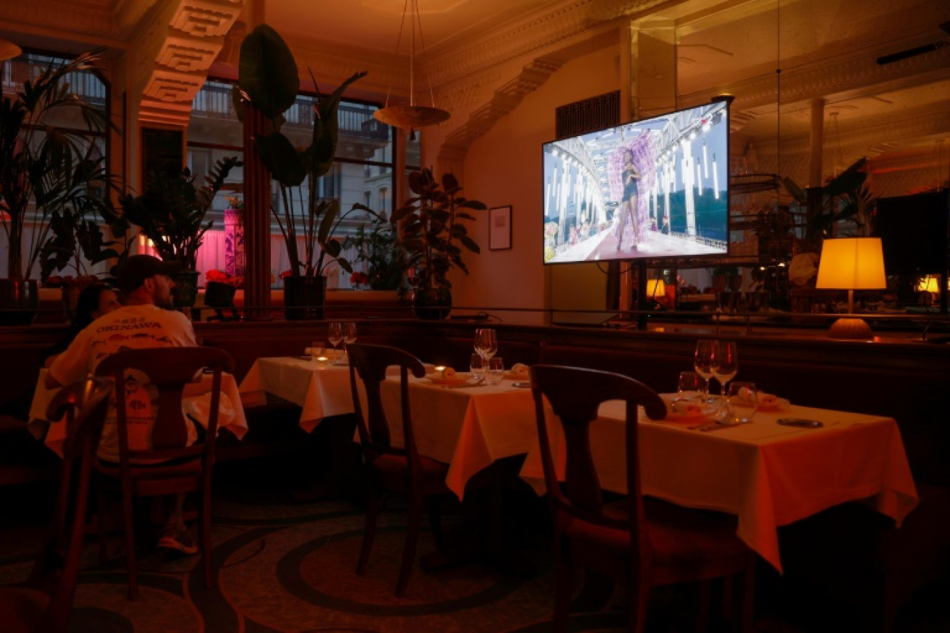 La cérémonie d'ouverture des Jeux olympiques de Paris 2024 passe sur un écran de télévision dans un restaurant à Paris, le 26 juillet 2024 © OLYMPIA DE MAISMONT