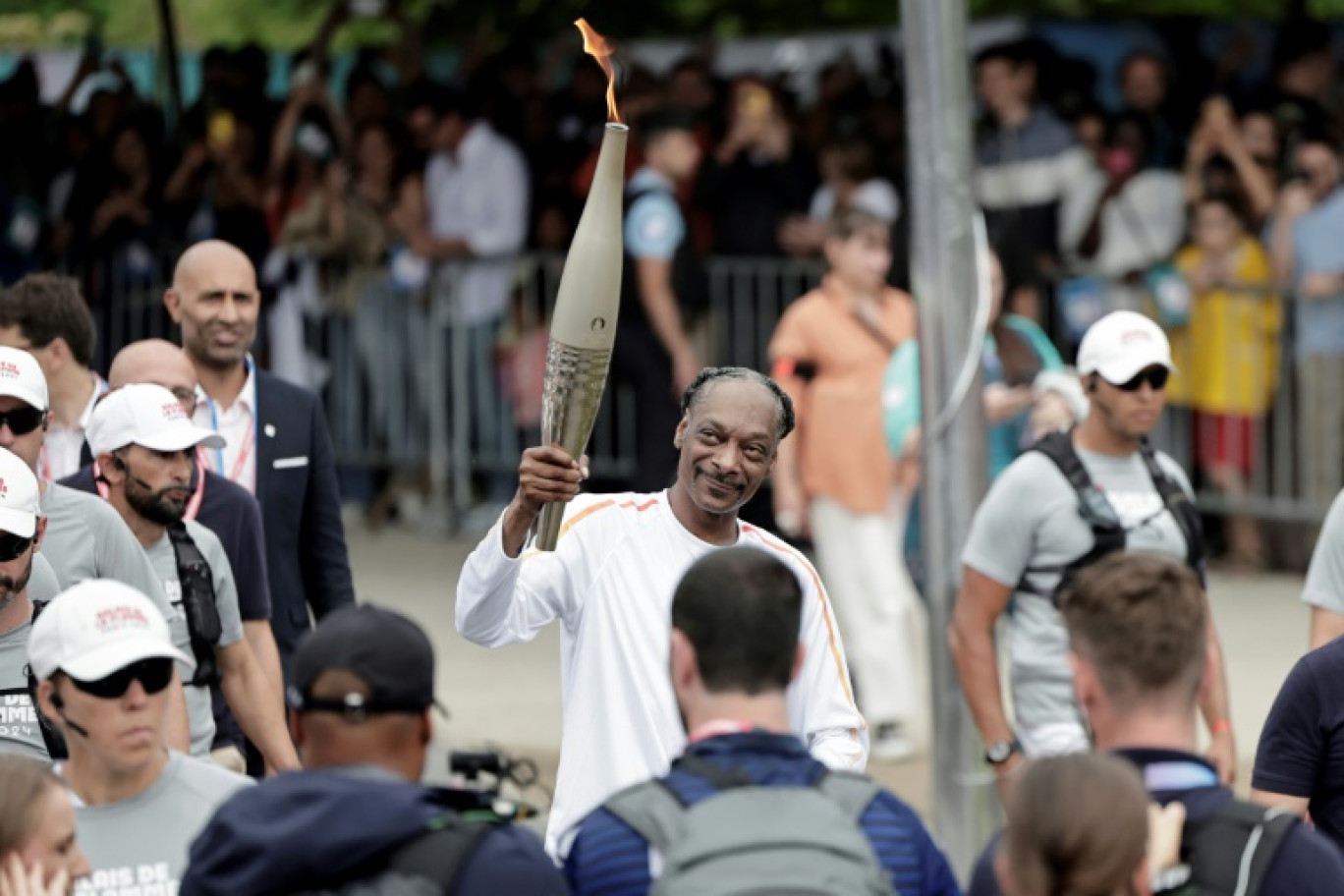 Le rappeur américain Snoop Dogg brandit la flamme olympique, le 26 juillet 2024 à Saint-Denis (Seine-Saint-Denis), au dernier jour du voyage flamme jusqu'à la cérémonie d'ouverture des Jeux olympiques à Paris © STEPHANE DE SAKUTIN