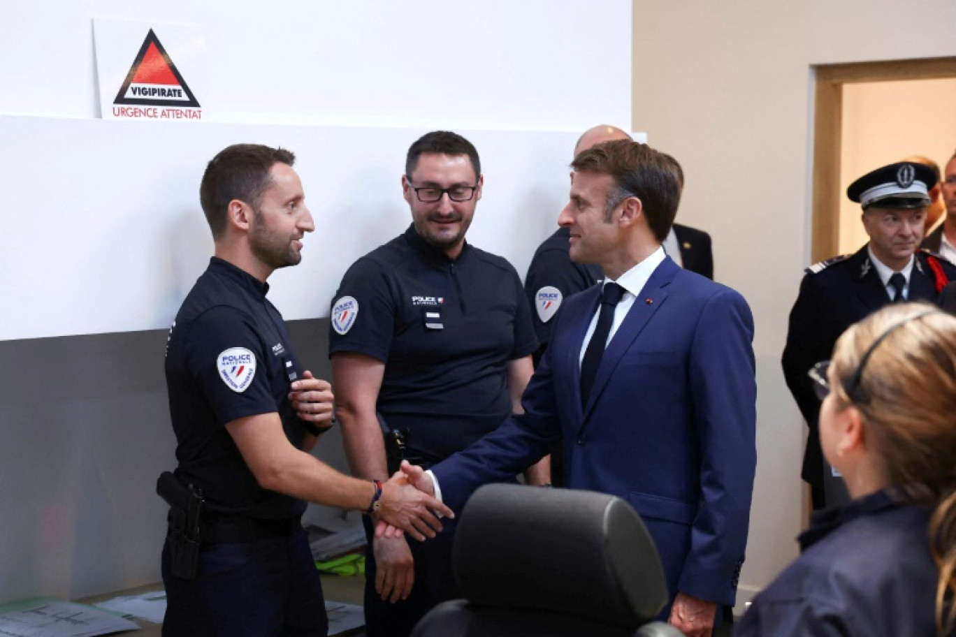 Le président Emmanuel Macron serre la main d'un policier, le 27 juillet 2024 à Paris © Yves Herman