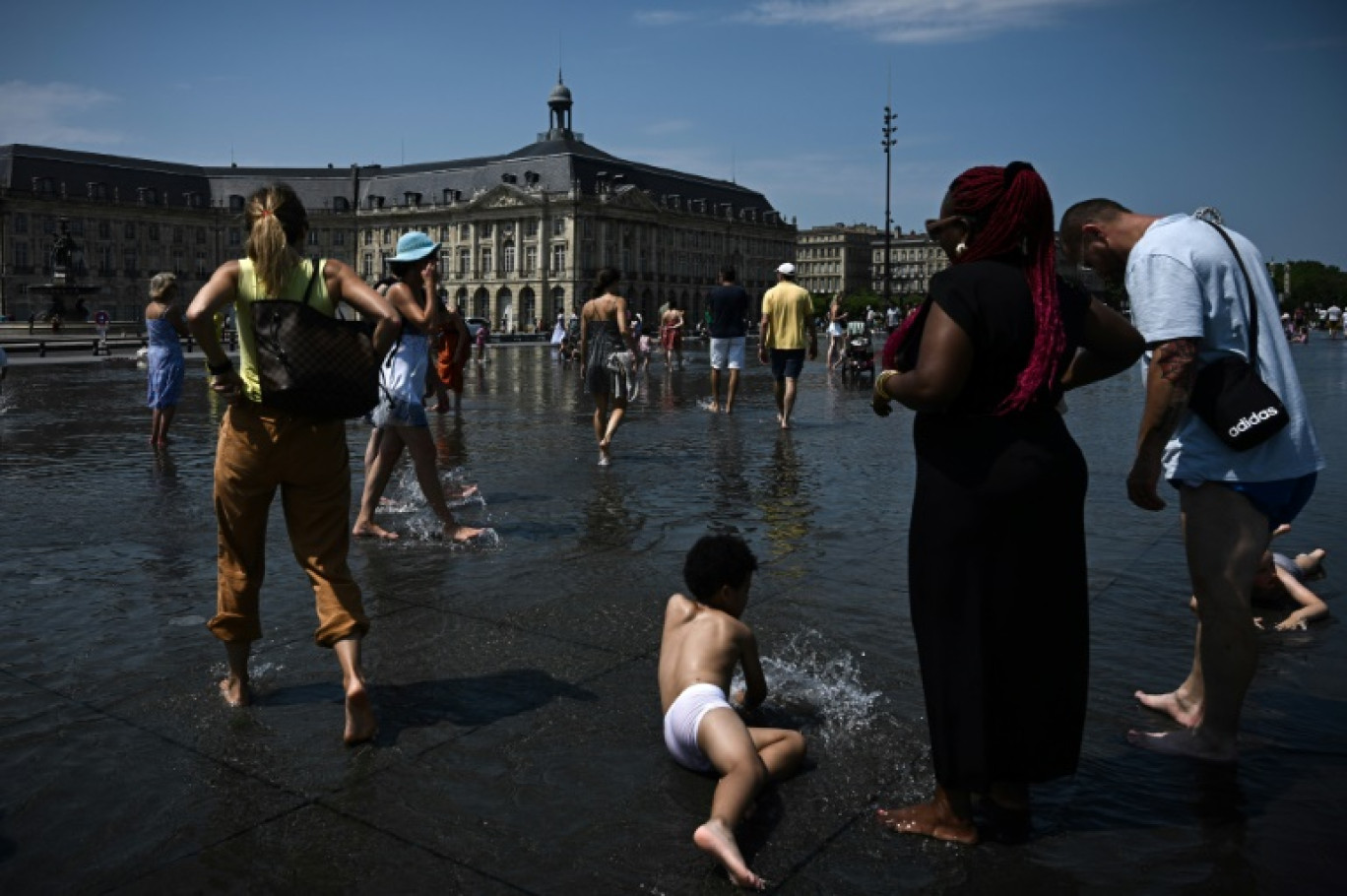 Le public se rafraîchit au "Miroir d'Eau" à Bordeaux, dans le sud-ouest de la France, le 28 juillet 2024, alors qu'une vague de chaleur pèse s'installe sur le sud du pays © Philippe LOPEZ