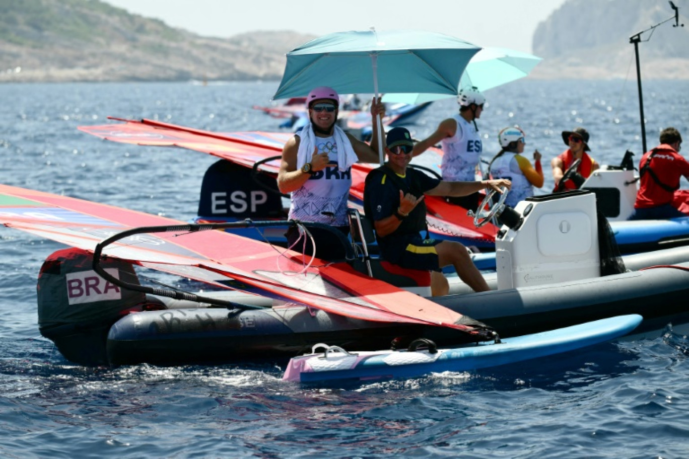 Le Brésilien Mateus Isaac attend de meilleures conditions météorologiques avant une épreuve masculine de planche à voile IQFoil aux JO-2024 au port de plaisance du Roucas-Blanc à Marseille, le 28 juillet 2024 © Christophe SIMON