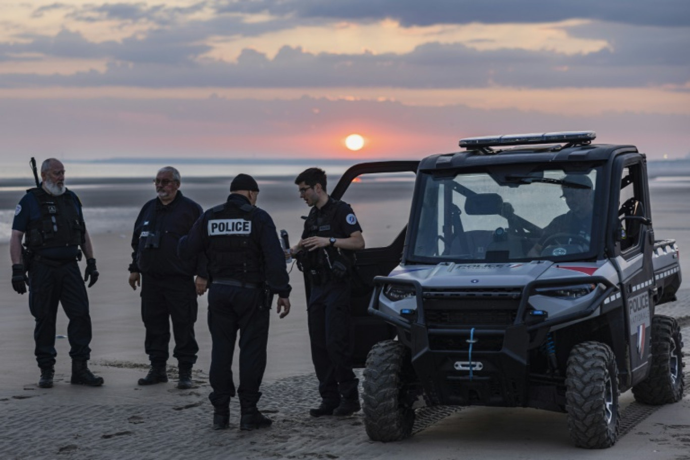 Des agents de police et de la police aux frontières patrouillent à l'aube sur la plage de Gravelines, le 20 juillet 2024 © Sameer Al-DOUMY