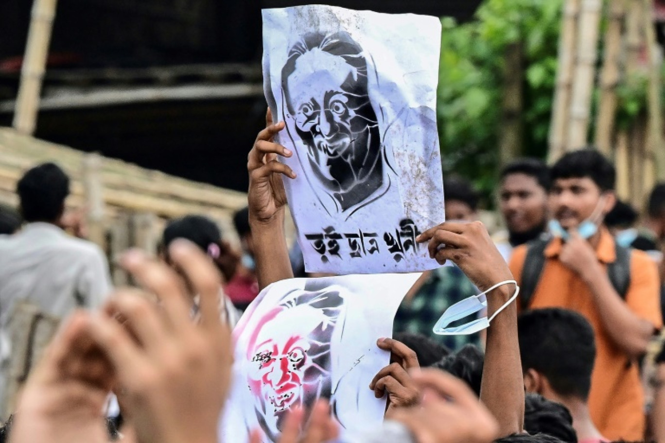 Portrait de Sheikh Hasina brandi par un manifestant avec le message "vous avez tué des étudiants", à Dacca au Bangladesh, le 3 août 2024 © MUNIR UZ ZAMAN