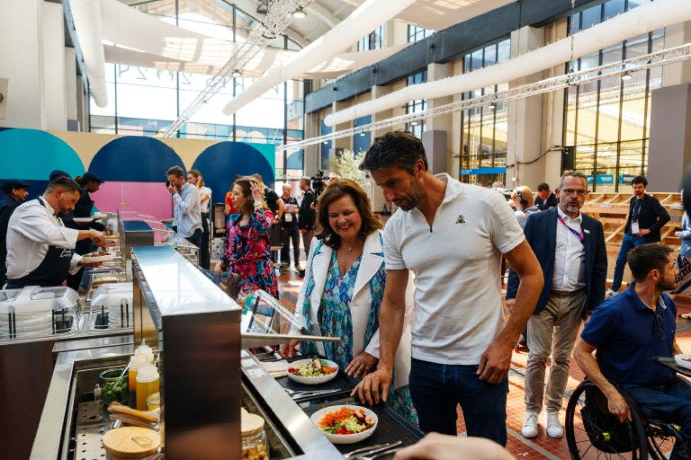 Le président du Comité d'organisation Paris-2024 Tony Estanguet et Nathalie Bellon-Szabo, PDG de Sodexo Live! choisissent leur repas lors d'un test du restaurant du village olympique, à Saint-Denis près de Paris le 25 juin 2024 © Dimitar DILKOFF