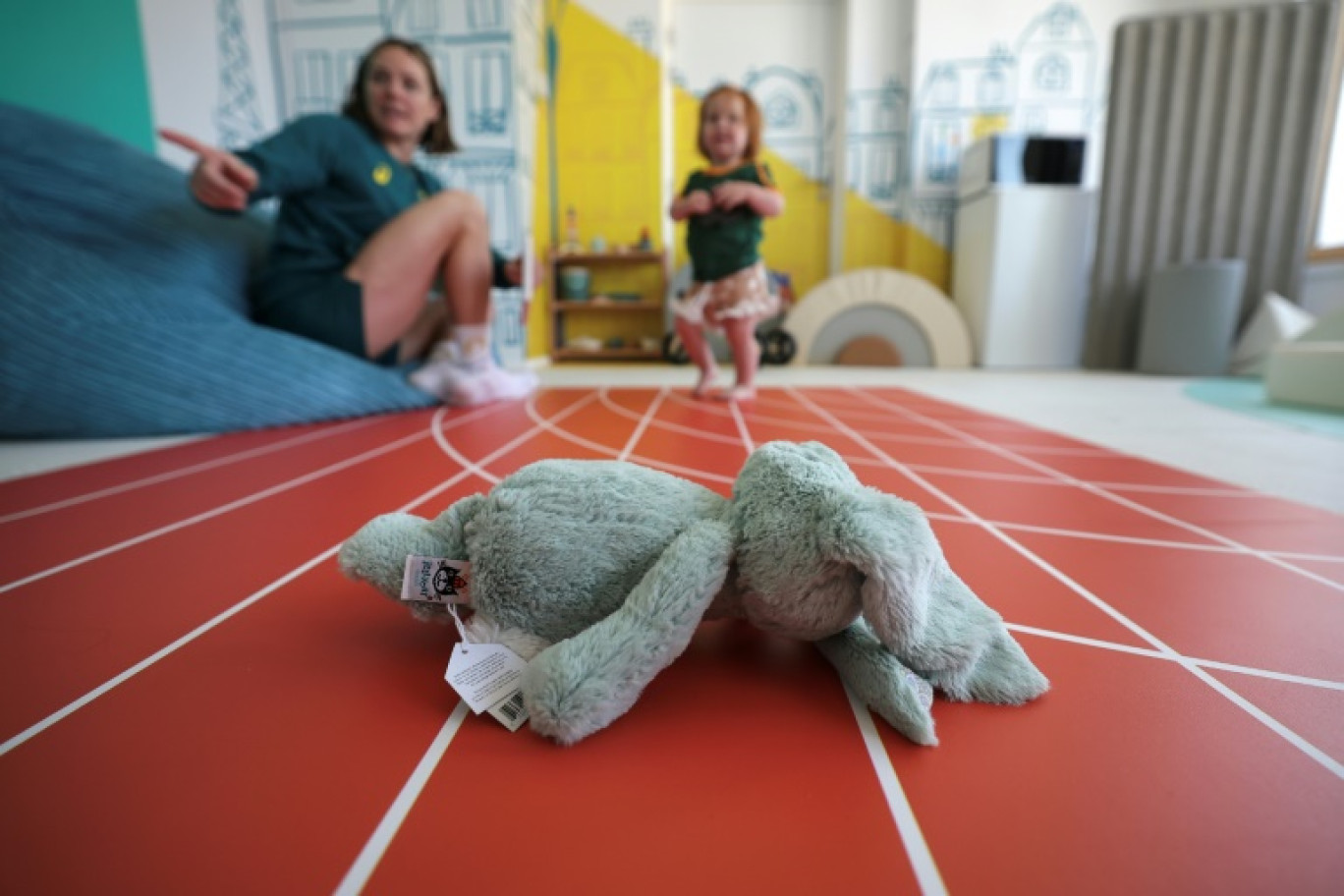 Keesja Gofers, membre de l'équipe australienne de water polo, joue avec sa fille Teleri dans l'espace dédié aux familles au village olympique de Saint-Denis, le 7 août 2024 © Valentine CHAPUIS