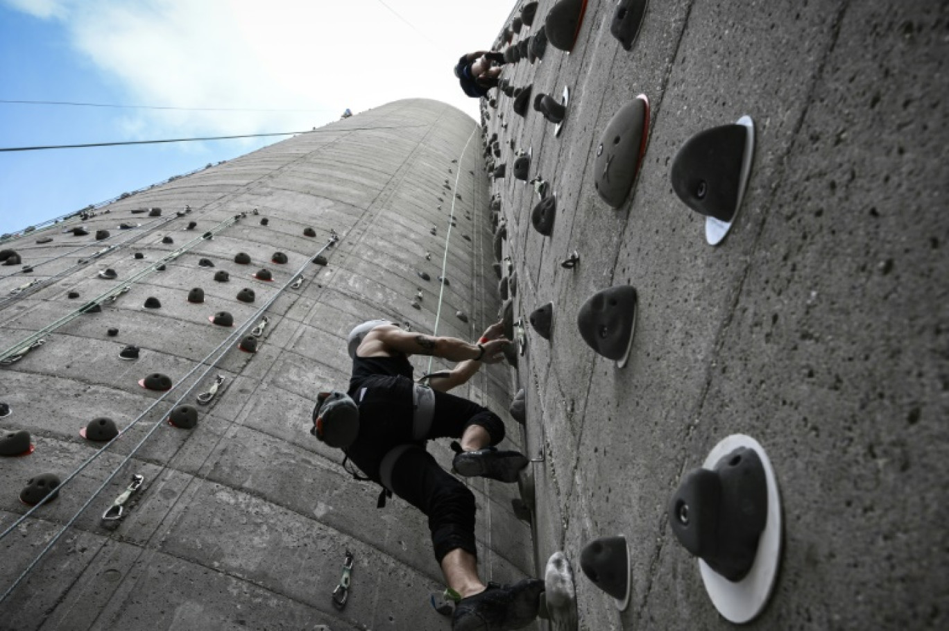 Des grimpeurs sur d'anciens silos à grain reconvertis en mur d'escalade, à Bordeaux, le 7 août 2024 © Philippe LOPEZ