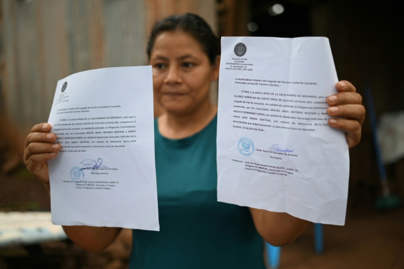 Rosa Romero montre deux assignations du tribunal de Jucuaran pour libérer la parcelle où elle vit sur la plage d'El Higueron, le 20 juillet 2024 au Salvador © Marvin RECINOS