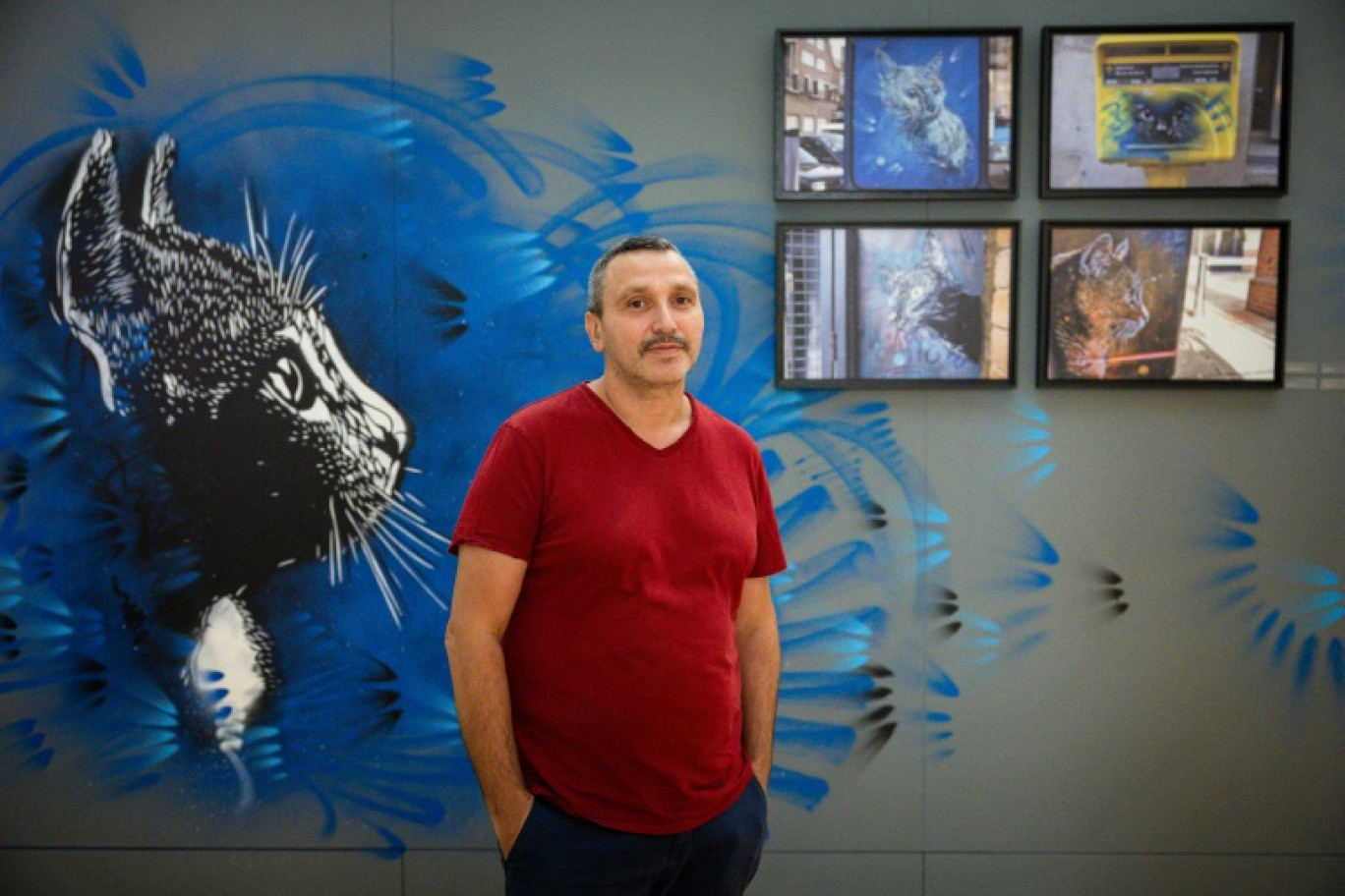 Le street artist parisien Christian Guemy, alias C215, devant ses peintures "Chat" exposées à la bibliothèque-musée "Inguimbertine" à l'Hôtel-Dieu de Carpentras, le 7 août 2024 dans le Vaucluse © CLEMENT MAHOUDEAU