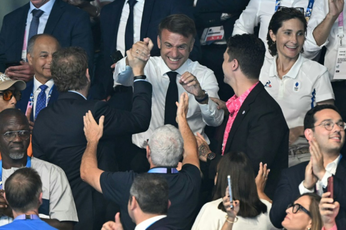 Emmanuel Macron (C) dans les tribunes après la victoire du nageur français Léon Marchand au 200 m 4 nages, le 2 août 2024 à La Defense Arena © Jonathan NACKSTRAND