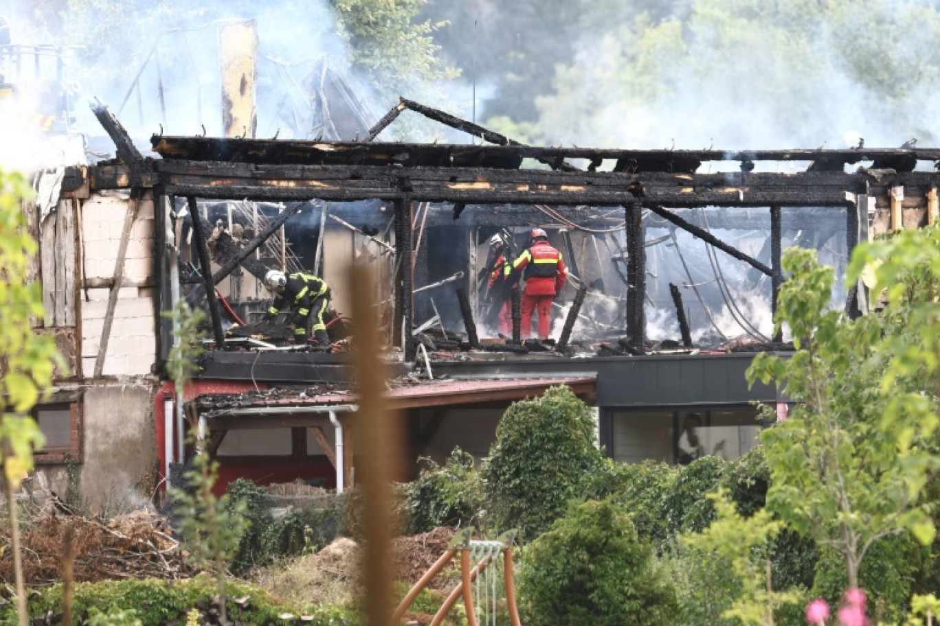 Des pompiers inspectent les décombres après l'incendie dans un gîte de vacances à Wintzenheim (Haut-Rhin, est de la France), le 9 août 2023 © Sebastien BOZON