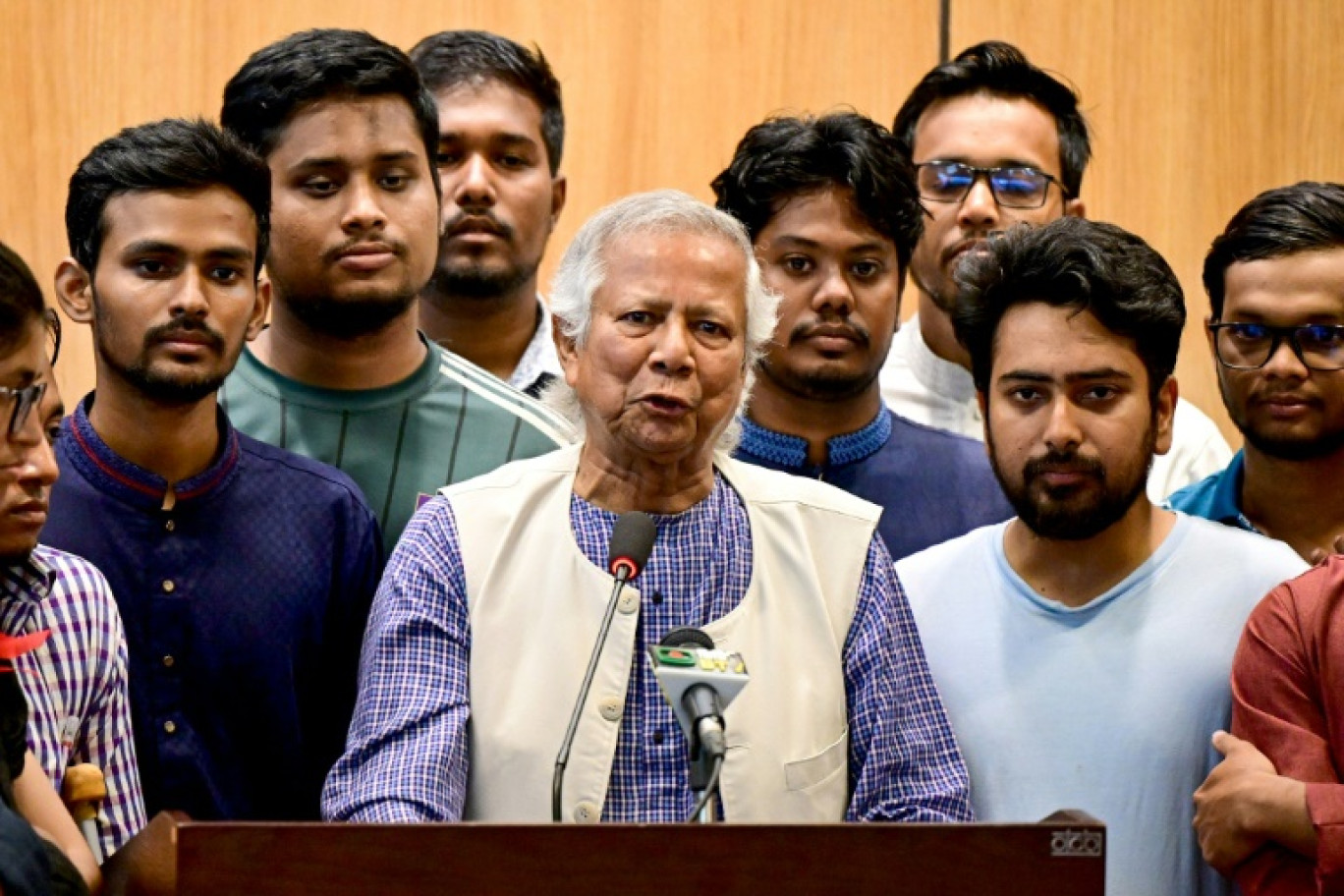 Le lauréat du prix Nobel de la paix Muhammad Yunus (au centre), lors d'une conférence de presse à son arrivée à l'aéroport international de Dacca (Bangladesh) le 8 août 2024 © Munir UZ ZAMAN