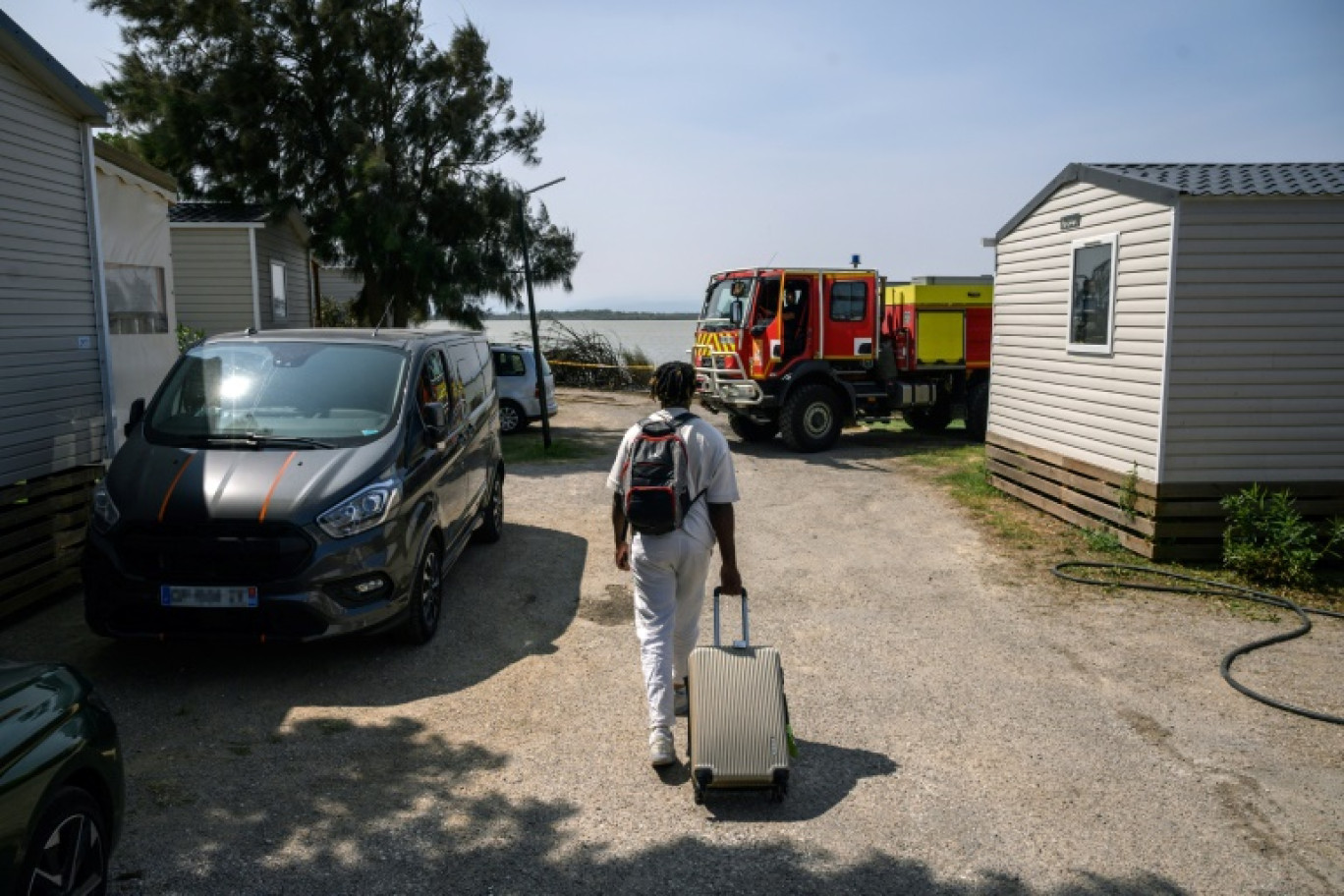 Un homme retourne le 19 août 2024 à sa caravane dans un camping de Canet-en-Roussillon, dans les Pyrénées-Orientales, évacué dans la nuit car menacé par un incendie © Ed JONES