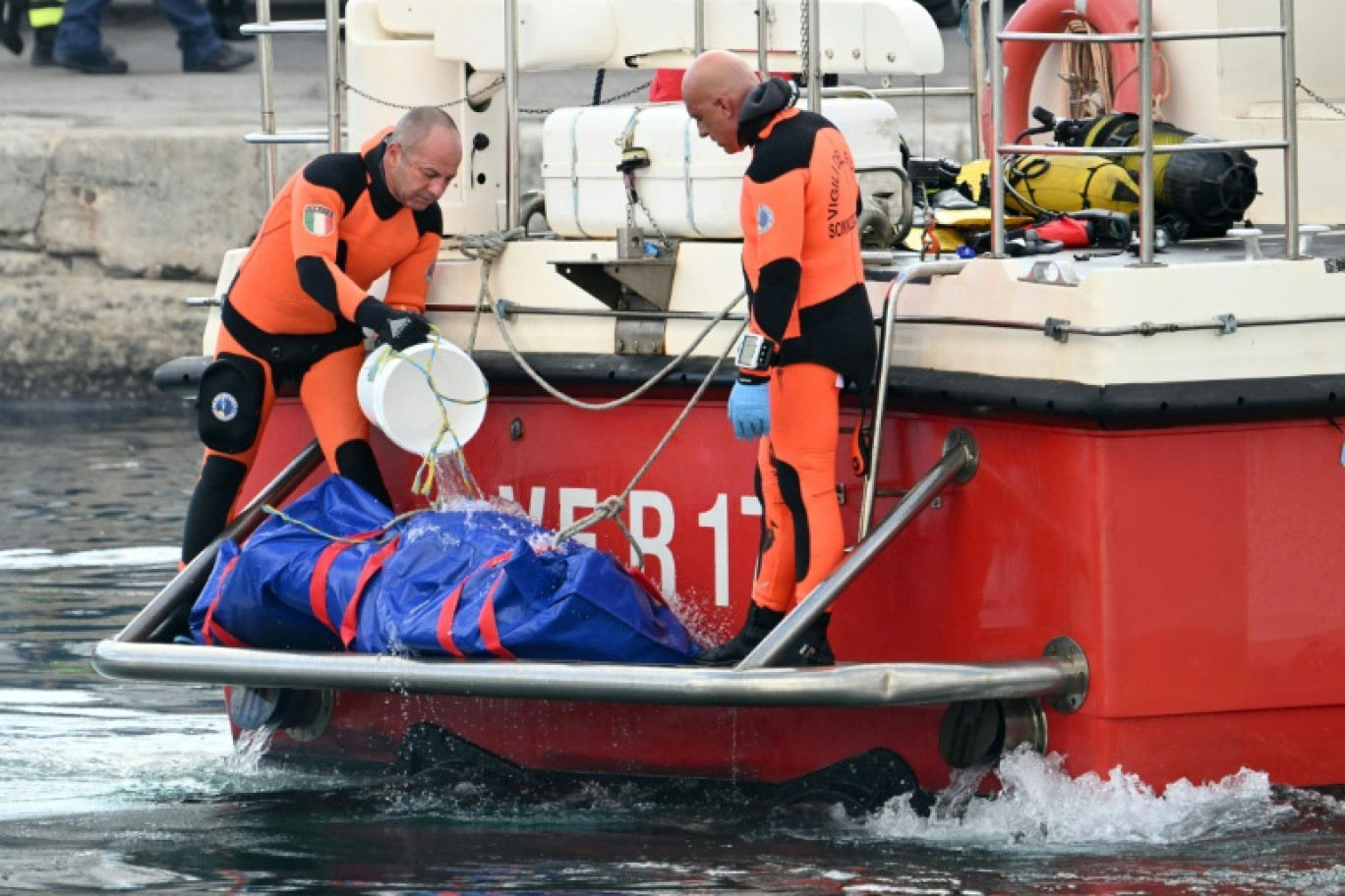 Retour au port italien de Porticello, en Sicile, des plongeurs recherchant les personnes portées disparues dans l'épave du yacht de luxe de Mike Lynch, un sac mortuaire à l’arrière du bateau, le 22 août 2024. © Alberto PIZZOLI